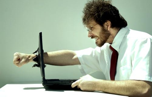 business man punched through laptop screen